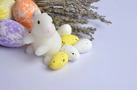 White Easter Bunny. Multi-colored Easter eggs. Bouquet of Lavender. Easter. L Stock Photos