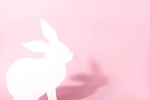 White Easter bunny on pink background. Easter holiday concept with cute handm 写真素材