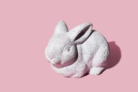 White Easter bunny rabbit with trendy shadow sitting on pink background. East 스톡 사진