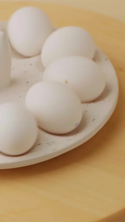 White Easter chicken eggs rotating on a festive tray Stock Footage 306918953