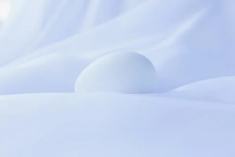 White Easter egg in the middle of heavenly white silky sheets Stock Photos
