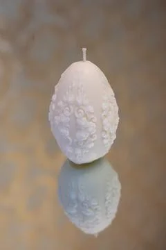 White easter egg soy wax candle. Mirror background Stock Photos