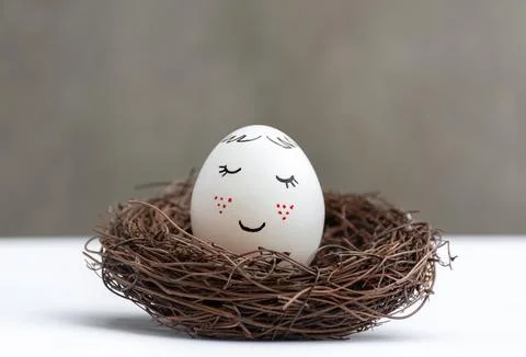 White Easter egg in wicker nest Stock Photos