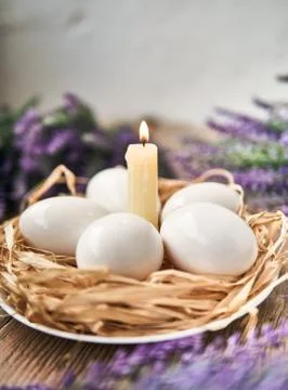 White Easter eggs with lighting candle. Happy Easter Concept. Congratulations Stock Photos