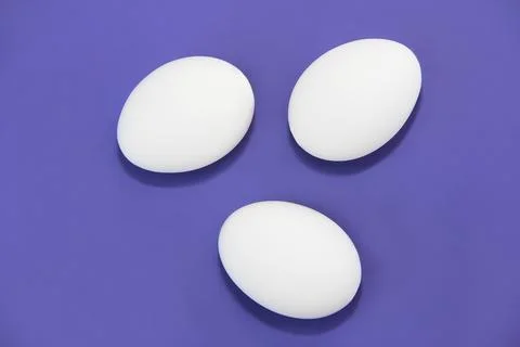 White easter eggs on purple background very peri Foto stock