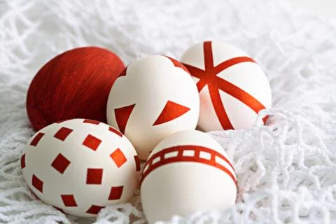 White Easter eggs with red geometric pattern on white mesh cloth Stock Photos