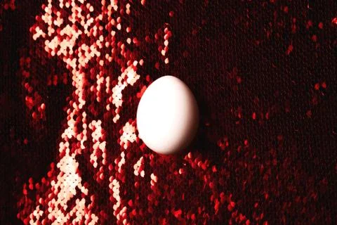 White egg on background of sequin. Stock Photos