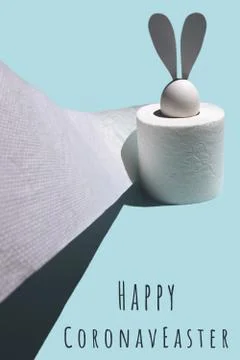 White egg with hare ears in a roll of toilet paper. Hard shadow on a light ba Stockfoto's