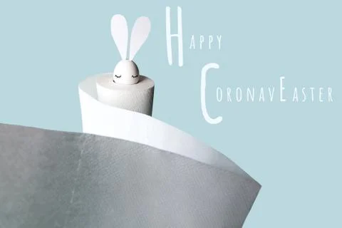 White egg with hare ears in a roll of toilet paper. Hard shadow on a light Stock Photos