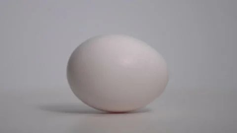 White egg rotate on the surface. Close up macro shot. White background. Before Stock Footage 134700363