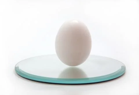 White egg standing up on a mirror Stock-Fotos