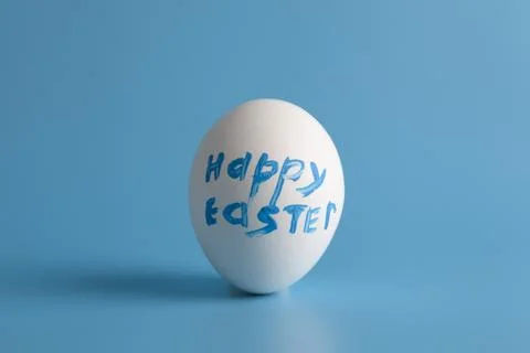 White egg  with text on a blue background. Stock Photos
