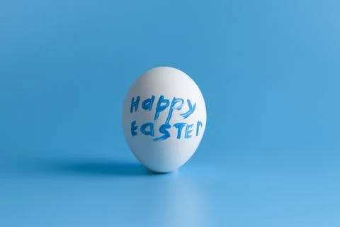White egg  with text on a blue background. Stock Photos