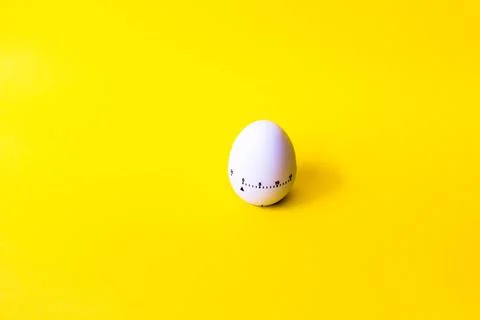 White egg timer on yellow background. Happy Easter in the kitchen. Home relat Foto stock