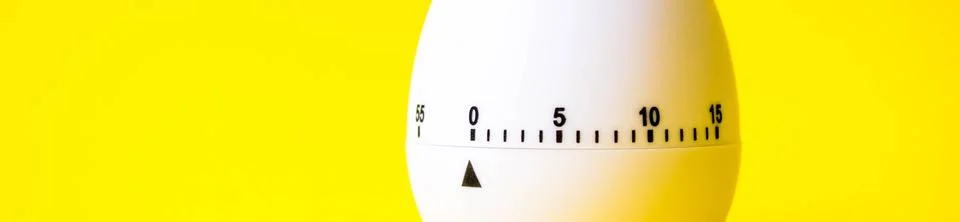 White egg timer on yellow background. Happy Easter in the kitchen. Home relat Stock Photos