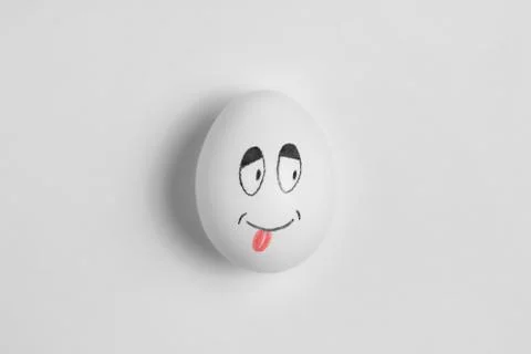White egg on a white background. Smile. Stock Photos