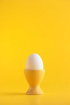 White egg on yellow background Stock Photos