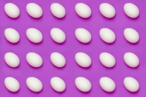 White eggs arranged on solid color background Stock Photos