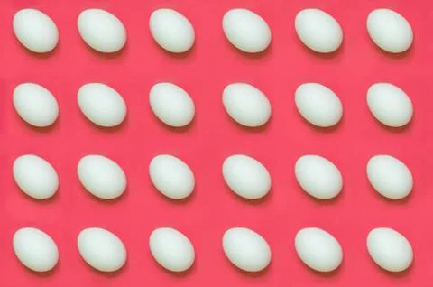White eggs arranged on solid color background Stock Photos
