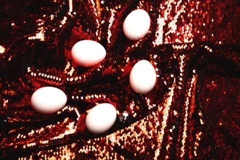 White eggs on background of sequin. Stock Photos