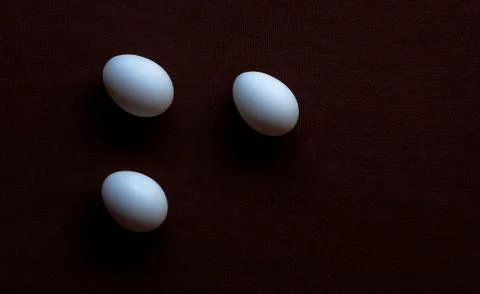White eggs on a brown background Stock Photos
