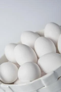 White eggs in a ceramic white corp on white background Foto stock