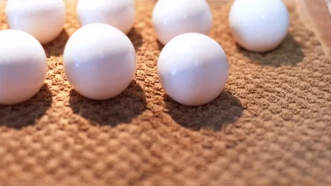 White eggs close-up on a brown towel. Woman washes dirty food before cooking Stock Footage 128828738