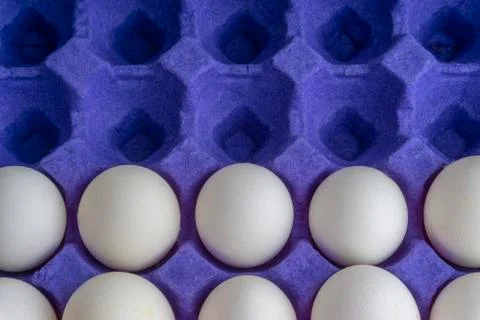 White eggs closeup in egg tray with selective focus and crop fragment 库存照片