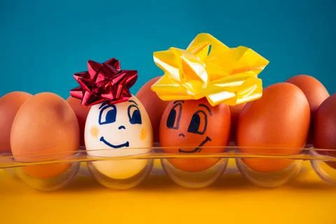 White eggs with different faces in a packet Stock Photos