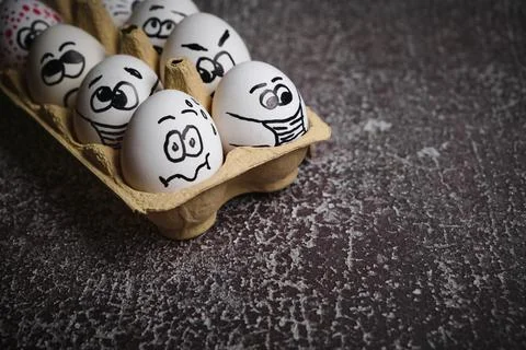 White eggs with drawn funny faces wearing medical masks at Easter holiday Stock Photos