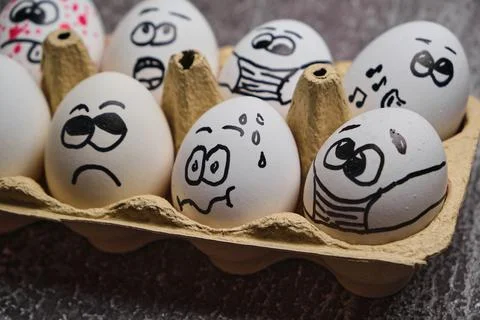 White eggs with drawn funny faces wearing medical masks at Easter holiday Stock Photos