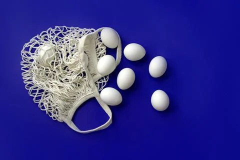 White eggs in a grid on a blue background Stock Photos
