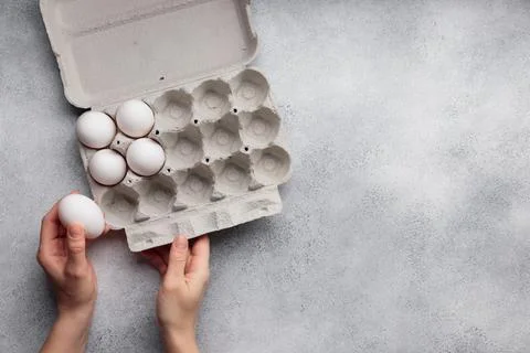 White eggs in a large paper container box top view Stock Photos
