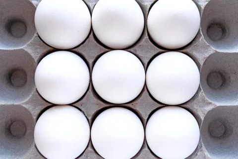 White eggs in a package on a blue background close-up view from above. Foto stock