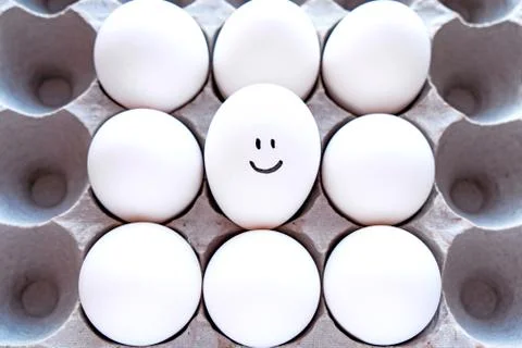 White eggs in a package on a blue background close-up view from above. Stock Photos