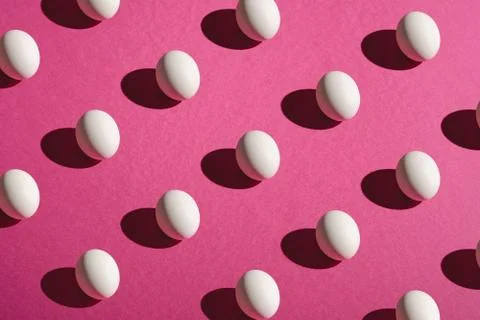 White eggs pattern on pink purple colors plain minimal background Stock Photos