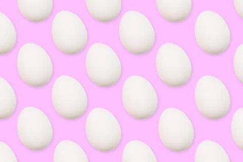 White eggs on a pink background. The flat position of the eggs arranged in a Stock Photos