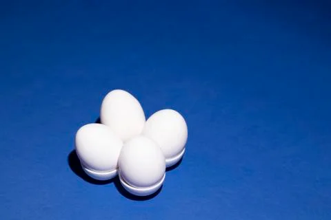 White eggs in a special form on a deep blue background Stock Photos