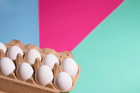 White eggs on a three-color background: blue, pink, green Stock Photos