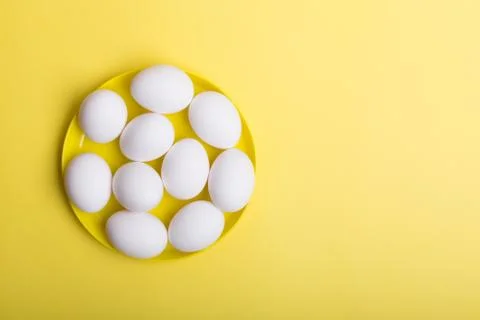 White eggs on the yellow background. Horizontal orientation 스톡 사진