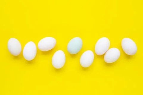 White eggs on yellow background. Stock Photos