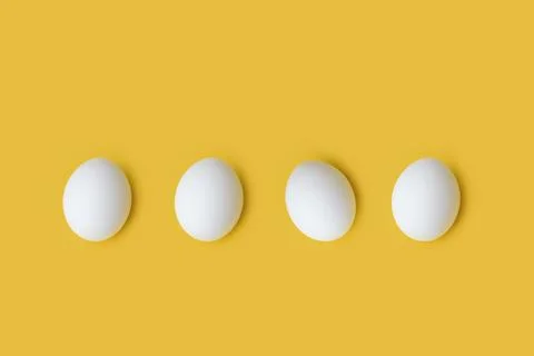 White eggs on yellow background Stock Photos