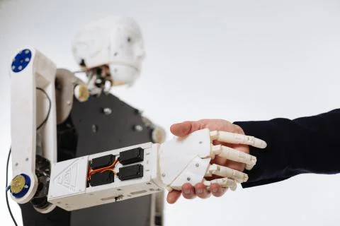 White elaborate robot shaking hands with human Stock Photos