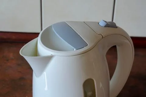 White electric kettle on the kitchen table. Stock Photos