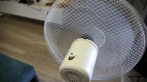 White electric standing fan operates indoors, close up view showing spinning Stock Footage 327187038