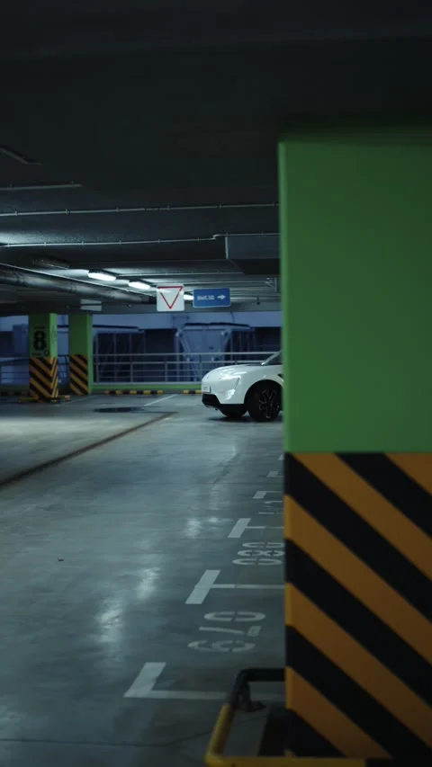 White electric SUV driving through underground parking garage 스톡 동영상 318418091