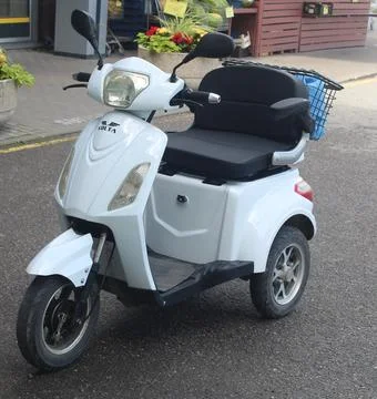 White Electric Three-Wheeled Mobility Scooter Parked Stock Photos