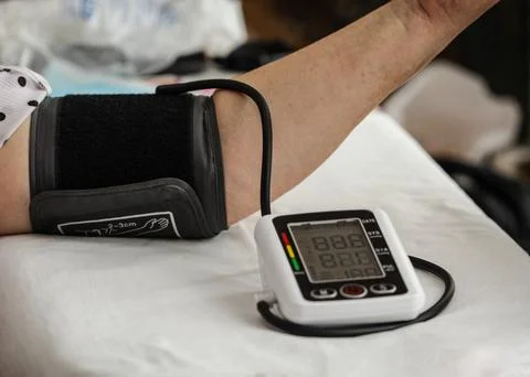 White electric tonometer on white table for measuring blood pressure with Stock Photos