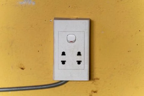 White electrical socket on a yellow plaster background Stock Photos