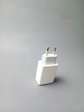 White electronic charger plug on gray background Stock Photos